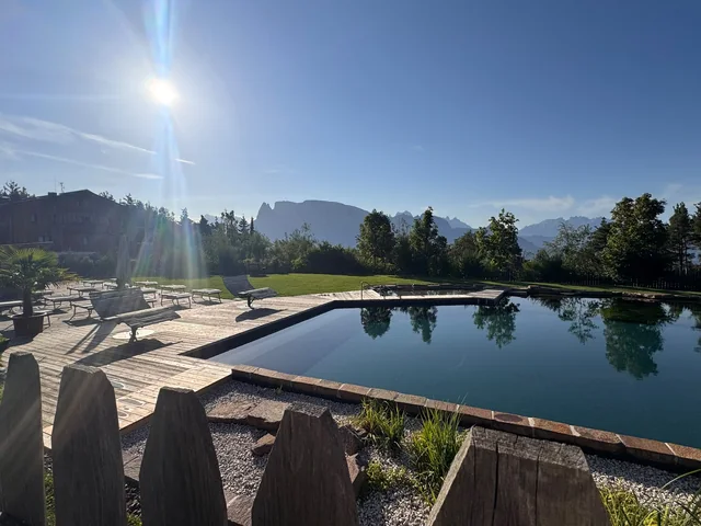 Naturpool mit Holzterrasse und Blick auf die Berge