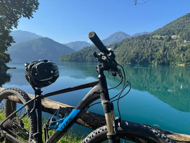 Mountainbike mit Helm am Ufer eines Bergsees